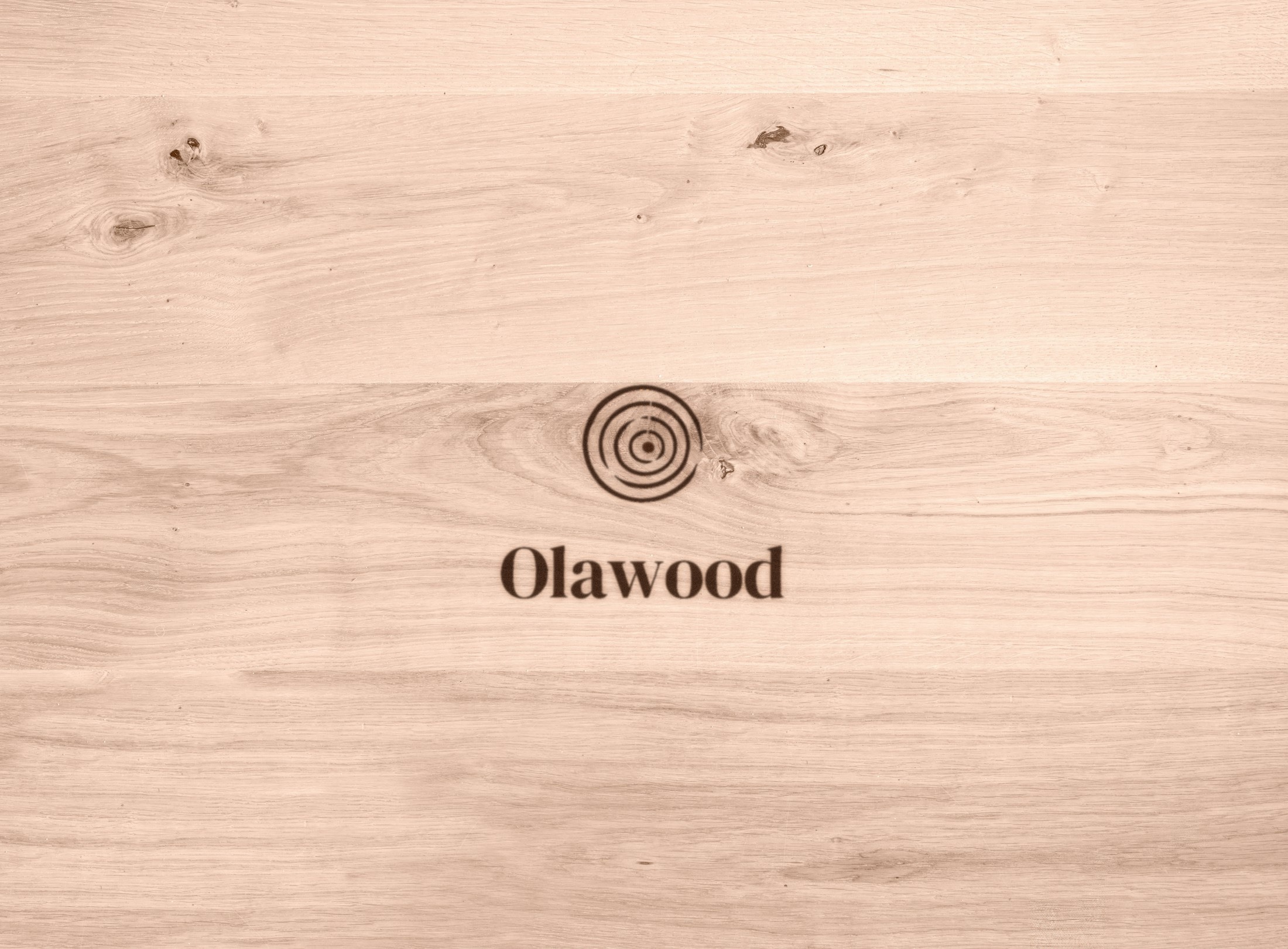 Açık renkli ahşap yüzeye yakılarak işlenmiş Olawood logosu konsepti